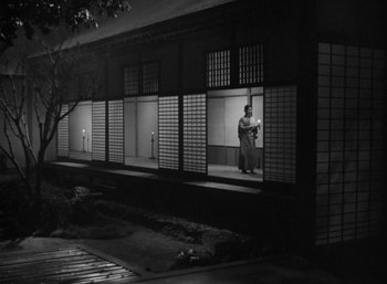 A man standing in front of a building at night