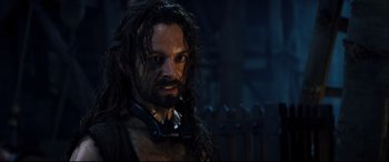 Movie still from “Underworld: Rise of the Lycans” (2009), directed by Patrick Tatopoulos – A man with long hair and a beard wearing headphones; Close Up shot, High angle