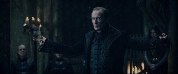 Movie still from “Underworld: Rise of the Lycans” (2009), directed by Patrick Tatopoulos – A man in a black jacket is standing in a dark room; Medium shot, Low angle