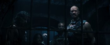 Movie still from “Underworld: Rise of the Lycans” (2009), directed by Patrick Tatopoulos – A group of men standing next to each other in front of a window; Medium shot, Over the shoulder angle