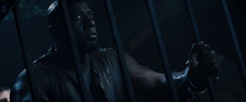 Movie still from “Underworld: Rise of the Lycans” (2009), directed by Patrick Tatopoulos – A man standing behind bars in a dark room; Close Up shot, High angle