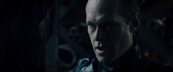 Movie still from “Underworld: Rise of the Lycans” (2009), directed by Patrick Tatopoulos – A man with a bald head wearing a leather jacket; Close Up shot, Over the shoulder angle
