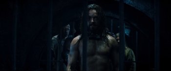 Movie still from “Underworld: Rise of the Lycans” (2009), directed by Patrick Tatopoulos – A man standing in a jail cell; Medium shot, Over the shoulder angle