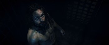 Movie still from “Underworld: Rise of the Lycans” (2009), directed by Patrick Tatopoulos – A man with long hair is standing in the dark; Medium shot, Overhead angle