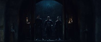 Movie still from “Underworld: Rise of the Lycans” (2009), directed by Patrick Tatopoulos – A group of men standing next to each other in front of an archway; Wide shot, Low angle