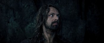 Movie still from “Underworld: Rise of the Lycans” (2009), directed by Patrick Tatopoulos – A man with long hair looking up into the sky; Close Up shot, Over the shoulder angle