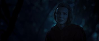 Movie still from “Underworld: Rise of the Lycans” (2009), directed by Patrick Tatopoulos – A woman is standing in the dark in a hoodie; Close Up shot, Over the shoulder angle