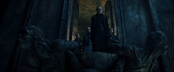 Movie still from “Underworld: Rise of the Lycans” (2009), directed by Patrick Tatopoulos – A group of people standing in front of a stone wall; Wide shot, Low angle