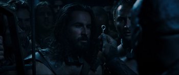 Movie still from “Underworld: Rise of the Lycans” (2009), directed by Patrick Tatopoulos – A man with long hair and a beard holding a ring in a dark room; Close Up shot, High angle
