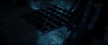 Movie still from “Underworld: Rise of the Lycans” (2009), directed by Patrick Tatopoulos – A metal grate on the ground in a dark room; Extreme Close Up shot, High angle