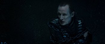 Movie still from “Underworld: Rise of the Lycans” (2009), directed by Patrick Tatopoulos – A man in chains sitting on the ground in the dark; Close Up shot, Overhead angle