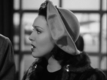 Movie still from “Unfaithfully Yours” (1948), directed by Preston Sturges – A black and white photo of a woman wearing a hat; Close Up shot, Over the shoulder angle