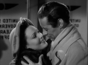 Movie still from “Unfaithfully Yours” (1948), directed by Preston Sturges – A man and a woman kissing each other in a black and white photo; Close Up shot, High angle