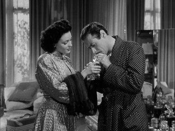 Movie still from “Unfaithfully Yours” (1948), directed by Preston Sturges – A man and a woman standing next to each other in a living room; Medium shot, High angle