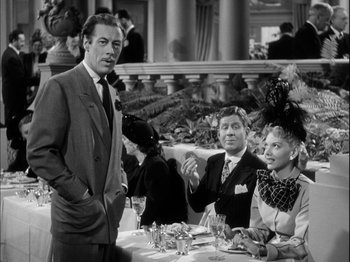 Movie still from “Unfaithfully Yours” (1948), directed by Preston Sturges – A group of people sitting around a table; Medium shot, Over the shoulder angle