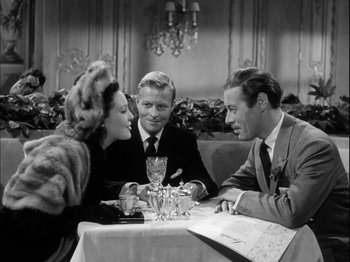 Movie still from “Unfaithfully Yours” (1948), directed by Preston Sturges – A group of people sitting at a table with wine glasses; Medium shot, High angle