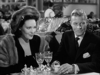 Movie still from “Unfaithfully Yours” (1948), directed by Preston Sturges – A man and a woman sitting at a dinner table; Medium shot, High angle