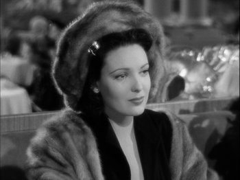 Movie still from “Unfaithfully Yours” (1948), directed by Preston Sturges – A woman wearing a fur coat and a fur hat; Close Up shot, High angle