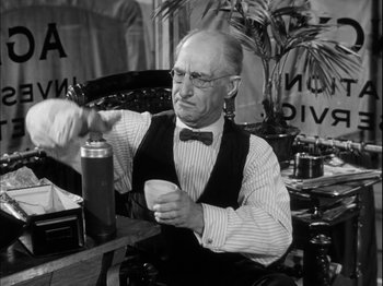 Movie still from “Unfaithfully Yours” (1948), directed by Preston Sturges – An older man sitting at a table with a cup in his hand; Close Up shot, Low angle