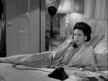 Movie still from “Unfaithfully Yours” (1948), directed by Preston Sturges – A black and white photo of a woman talking on a phone; Medium shot, High angle