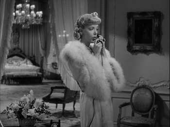 Movie still from “Unfaithfully Yours” (1948), directed by Preston Sturges – An old photo of a woman talking on a phone; Medium shot, High angle