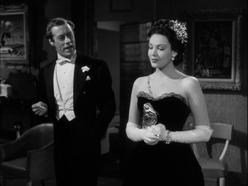 Movie still from “Unfaithfully Yours” (1948), directed by Preston Sturges – A man and a woman standing next to each other in formal wear; Medium shot, Over the shoulder angle