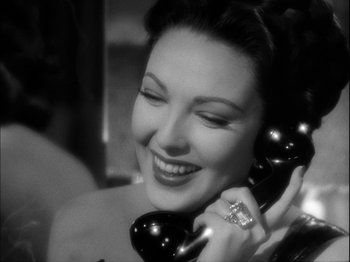 Movie still from “Unfaithfully Yours” (1948), directed by Preston Sturges – A beautiful woman talking on a black phone; Close Up shot, High angle