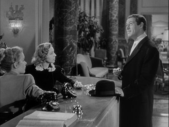Movie still from “Unfaithfully Yours” (1948), directed by Preston Sturges – Two women and a man at a counter; Medium shot, Low angle
