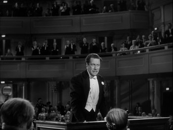 Movie still from “Unfaithfully Yours” (1948), directed by Preston Sturges – A black and white photo of a man in a tuxedo; Medium shot, High angle