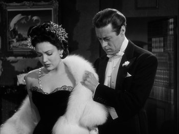 Movie still from “Unfaithfully Yours” (1948), directed by Preston Sturges – A man and a woman standing next to each other in formal wear; Medium shot, Low angle