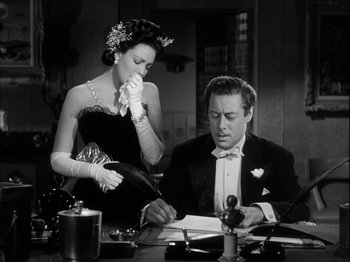Movie still from “Unfaithfully Yours” (1948), directed by Preston Sturges – A man and a woman sitting at a table; Medium shot, Low angle
