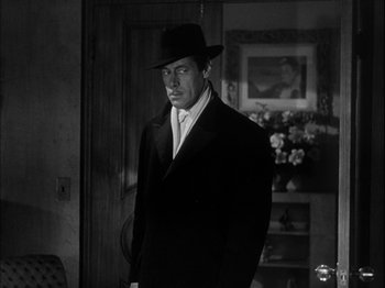 Movie still from “Unfaithfully Yours” (1948), directed by Preston Sturges – A black and white photo of a man in a suit and hat; Medium shot, Over the shoulder angle