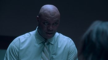 Movie still from “Unforgettable” (2017), directed by Denise Di Novi – A bald man in a white shirt and a tie; Close Up shot, Over the shoulder angle