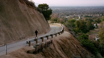 Movie still from “Unforgettable” (2017), directed by Denise Di Novi – A person is walking down the side of a hill; Extreme Wide shot, High angle