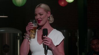 Movie still from “Unforgettable” (2017), directed by Denise Di Novi – A woman holding a glass of beer and a microphone; Close Up shot, Over the shoulder angle