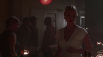 Movie still from “Unforgettable” (2017), directed by Denise Di Novi – A woman in a white dress standing in a room with other people; Medium shot, Over the shoulder angle