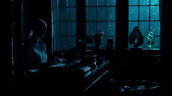 Movie still from “Unforgettable” (2017), directed by Denise Di Novi – A woman sitting at a desk in front of a window; Wide shot, Low angle