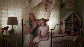 Movie still from “Unforgettable” (2017), directed by Denise Di Novi – A woman is combing the hair of a little girl; Medium shot, High angle