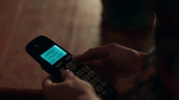 Movie still from “Unforgettable” (2017), directed by Denise Di Novi – A person holding a cell phone in their hand; Extreme Close Up shot, High angle
