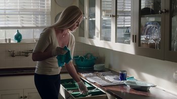 Movie still from “Unforgettable” (2017), directed by Denise Di Novi – A woman in white shirt cleaning a counter top; Medium shot, Low angle