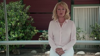 Movie still from “Unforgettable” (2017), directed by Denise Di Novi – A woman in a pink shirt is sitting outside; Medium shot, Low angle