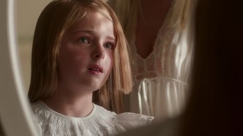 Movie still from “Unforgettable” (2017), directed by Denise Di Novi – A little girl in a white dress looking into a mirror; Close Up shot, Over the shoulder angle