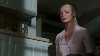 Movie still from “Unforgettable” (2017), directed by Denise Di Novi – A woman in a pink shirt is in a kitchen; Close Up shot, Low angle