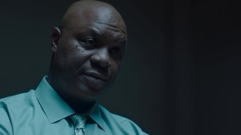 Movie still from “Unforgettable” (2017), directed by Denise Di Novi – A bald man wearing a blue shirt and a tie; Close Up shot, Low angle