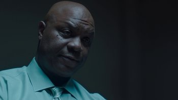 Movie still from “Unforgettable” (2017), directed by Denise Di Novi – A bald man wearing a blue shirt and a tie; Close Up shot, Low angle