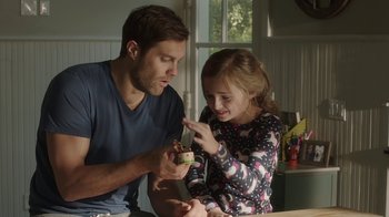 Movie still from “Unforgettable” (2017), directed by Denise Di Novi – A man and a little girl are looking at a piece of cake; Medium shot, Over the shoulder angle