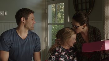 Movie still from “Unforgettable” (2017), directed by Denise Di Novi – A woman kissing a girl on the cheek of a man; Medium shot, Over the shoulder angle