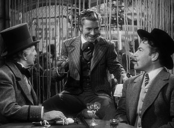 Movie still from “Union Pacific” (1939), directed by Cecil B. DeMille – A group of men sitting around a table; Medium shot, Over the shoulder angle