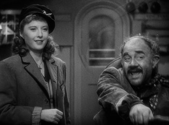 Movie still from “Union Pacific” (1939), directed by Cecil B. DeMille – An old photo of a man and a woman; Medium shot, High angle