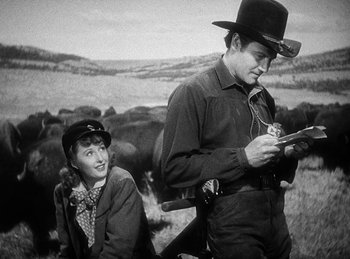 Movie still from “Union Pacific” (1939), directed by Cecil B. DeMille – A man and a woman looking at a cell phone; Medium shot, Over the shoulder angle